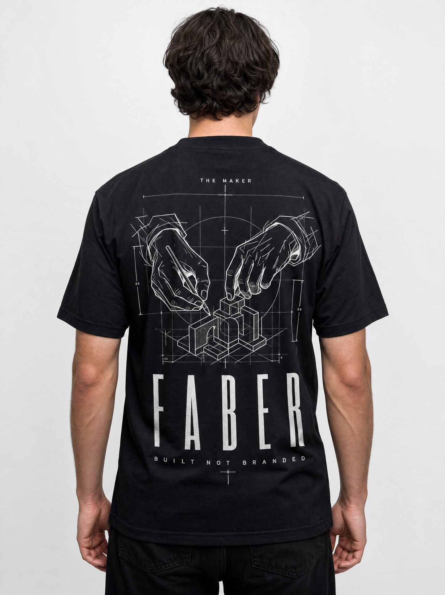A man viewed from the back wearing a black short-sleeve t-shirt with a large white graphic print on the back. The graphic features blueprint-style hands assembling a 3D structure, with the brand name 'FABER' printed in large white letters below.