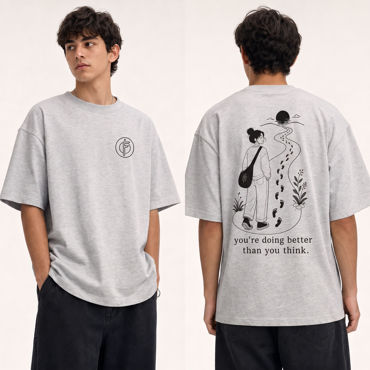Editorial studio photo of a model wearing an oversized light heather grey Icy Rock heavyweight t-shirt with a graphic reading YOU ARE DOING BETTER THAN YOU THINK in black ink, relaxed streetwear fit, clean studio background.