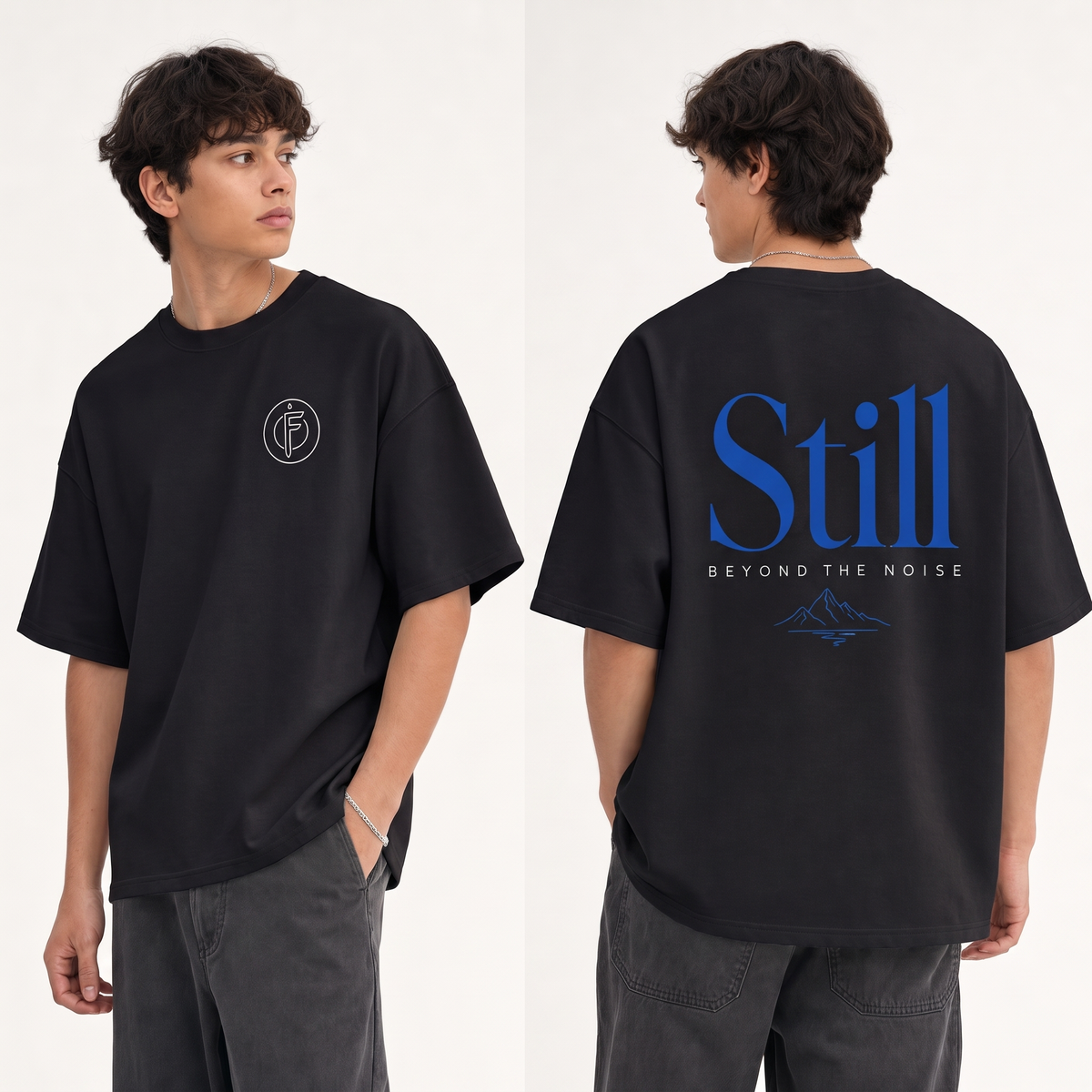 Editorial studio photo of a model wearing an oversized black heavyweight t-shirt with the STILL BEYOND THE NOISE graphic, front and back views, relaxed streetwear fit, clean studio background.